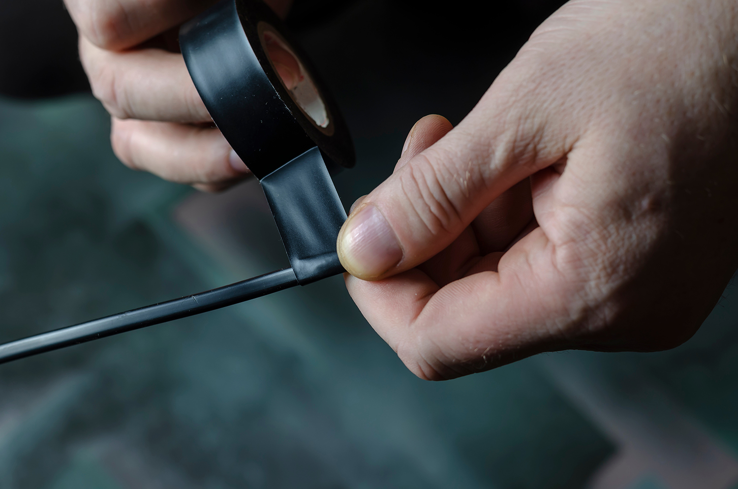 a person putting electrical tape on a wire