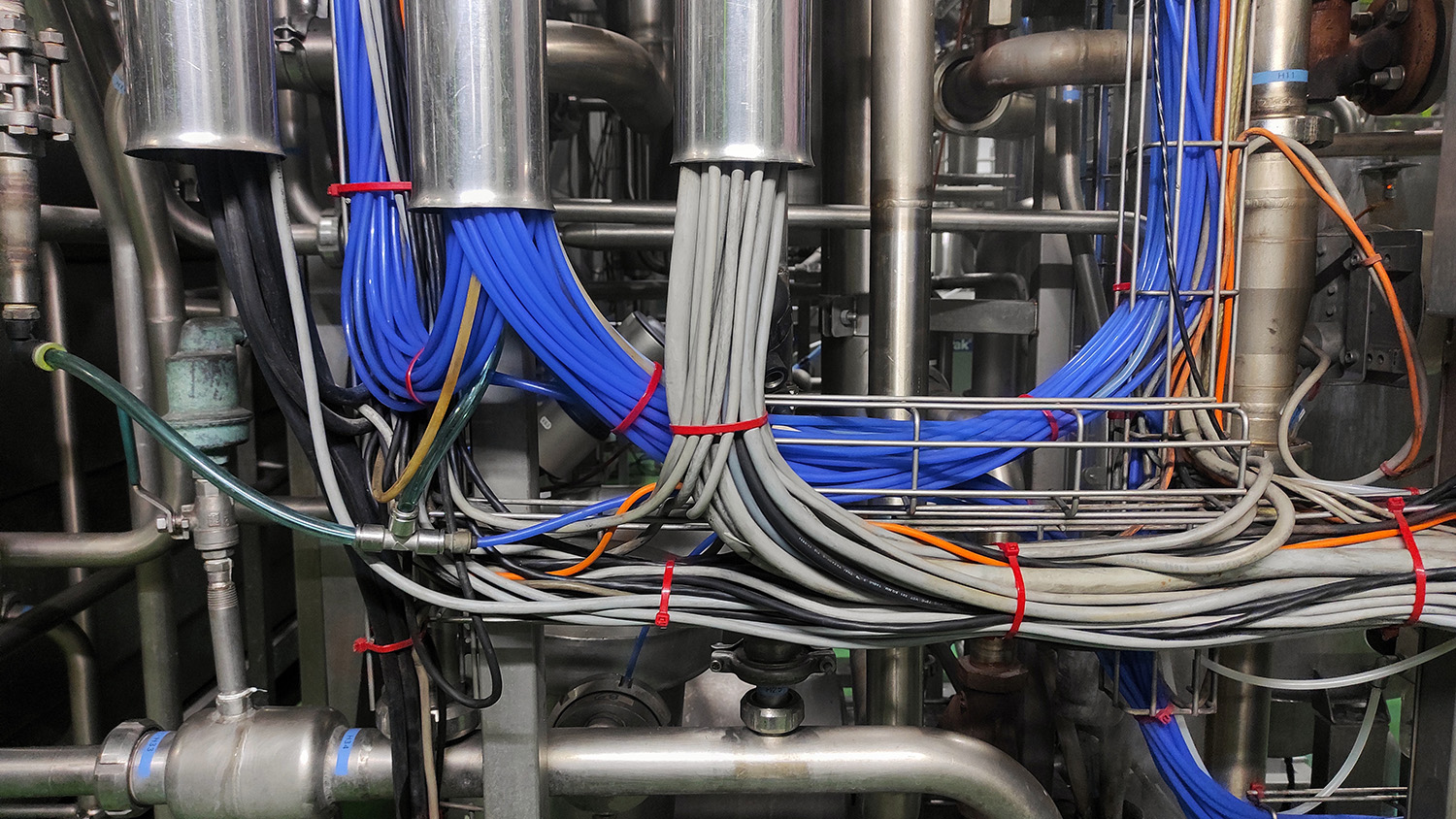 A thick bundle of several blue and gray wires held together with heavy-duty cable ties
