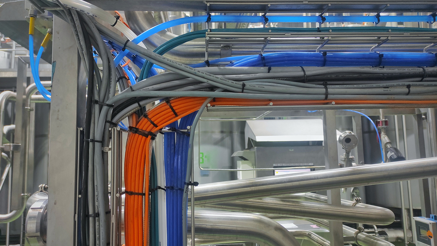 Electrical cables fastened with 3M heavy-duty cable ties in an industrial workspace.